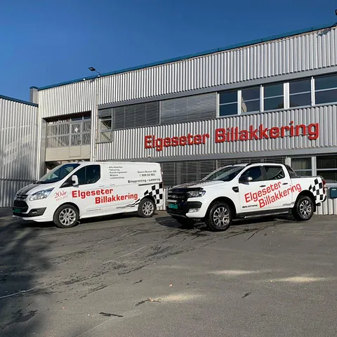 Hvit varebil og pickup foran Elgeseter Billakkerings lokaler